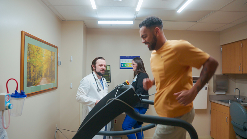 Man on treadmill begin monitored by a male physician