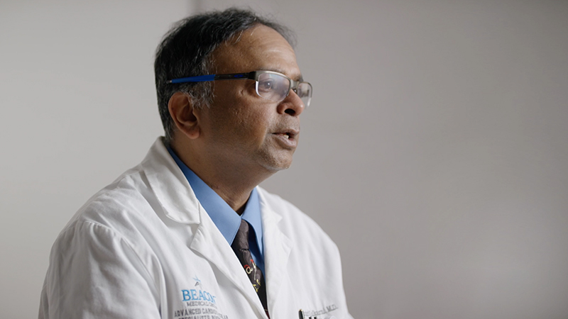 Male provider in white lab coat, talking to someone off camera