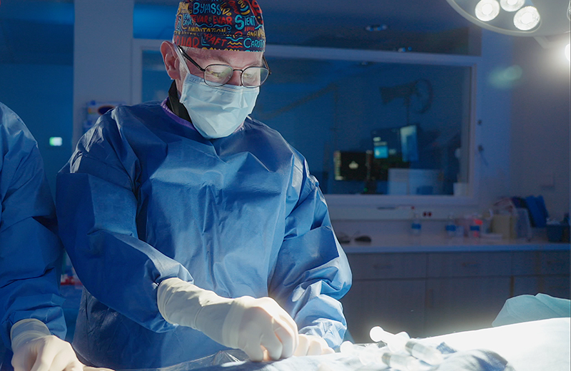 Male surgeon in scrubs performs task in operating room